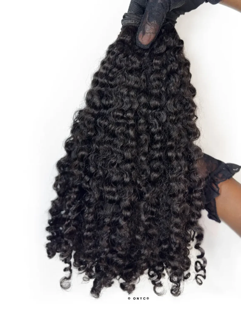 ONYC Kinky Curly Hair - ONYC Raw Kinky Curly Bundles – Indian Kinky Curly Human Hair Weave Bundles in Water Kinky Loose Kinks ClassiQUE Collection Double Drawn Weft Bundle Natural Black 1B. Indian Kinky Curly Hair Bundles – ONYC® Loose Kinks 3C™ ClassiQUE™, showing real 3C curls in a loose 3C texture with full, voluminous curly hair. These Textured Curly Hair Extensions, 3C curly hair bundles, and Kinky curly hair bundles are made from Virgin Hair Bundle crafted with Raw Cuticle Hair, Indian Kinky Curly Hair, and Indian Remy Hair for a super double drawn, thick hair, finest quality finish. Celebrated as the best kinky curly human hair weave, all ONYC kinky textures, including the popular 3B3C, provide the best kinky curly texture for a seamless, natural-looking blend. These Kinky Curly Human Hair Bundles and Afro Kinky Curly Human Hair bundles are tangle free that does not shed, durable, long-lasting, soft, and worth the investment. Perfect as Human Hair Curly Weave or Textured curly bundles for styles ranging from everyday natural to glamorous, available in lengths from under 14, 14 in to 18, 18 in to 24 in, and over 24 in. Featured in ONYC Human Hair Bundles, ONYC Hair Products Review, ONYC Hair Reviews, and ONYC curly hair extensions, these are trusted as the Best african american curly hair extensions, Black-owned human hair extensions, and best hair extensions for African American hair. Available to buy online or in store, with local pickup, fast shipping, and free shipping usa, plus delivery near me in Washington DC and Maryland.